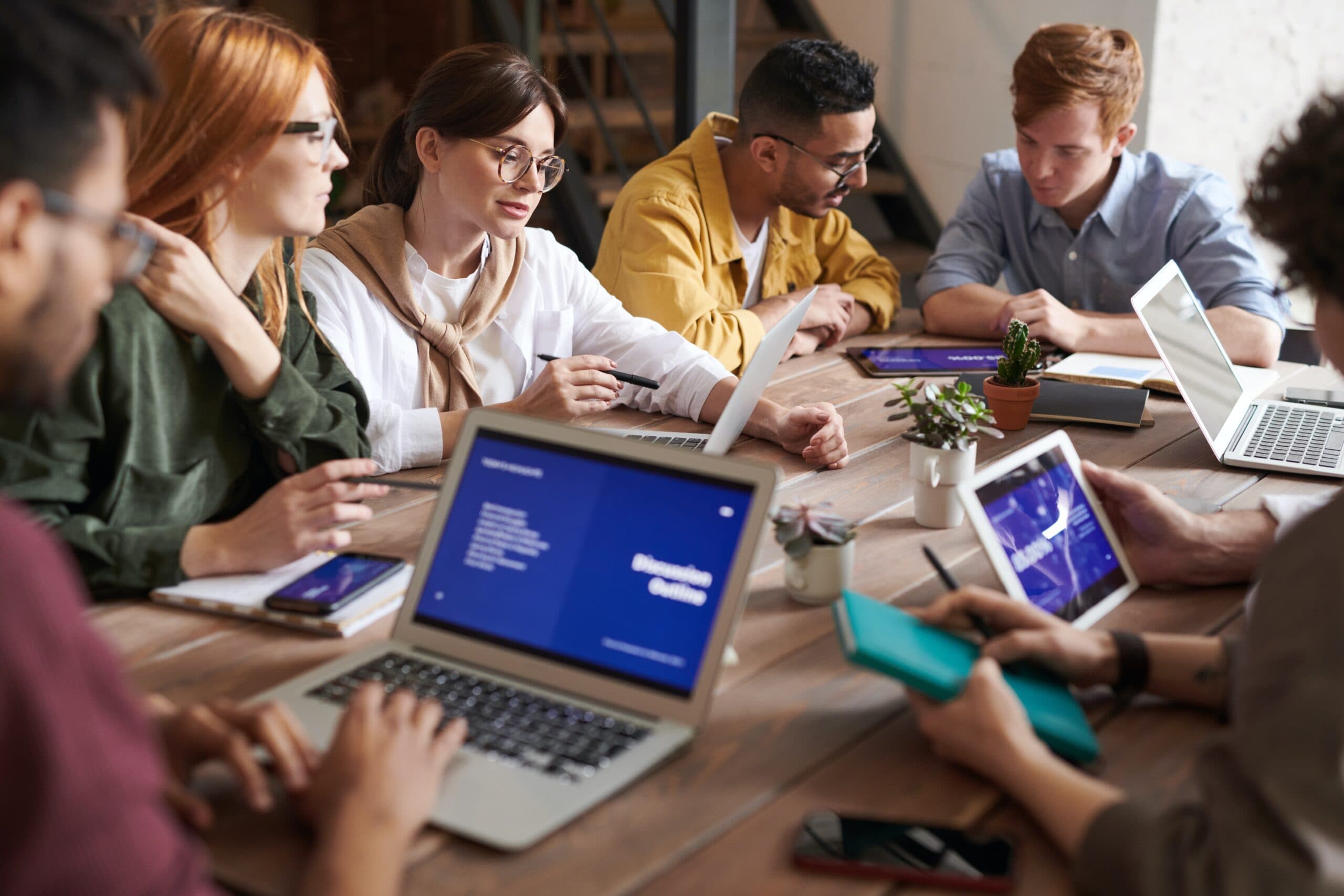 Team collaborating around laptops in a modern office